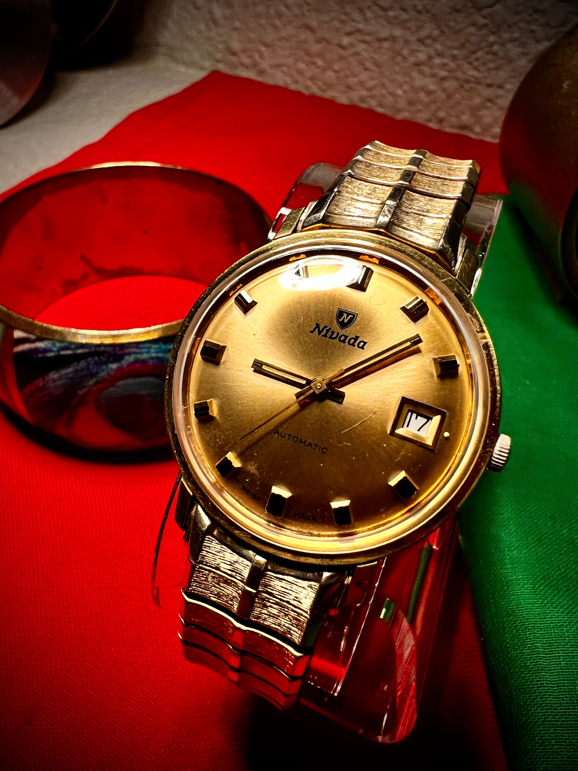 #1351 Nivada Date Automatic Gold color with Gold dial newish beautiful S.S back Spidiel USA gold filled caps all original watch great opportunity for Collectors rate watch in excellent running and beautiful condition. Power 266 beat error 0.1 ms