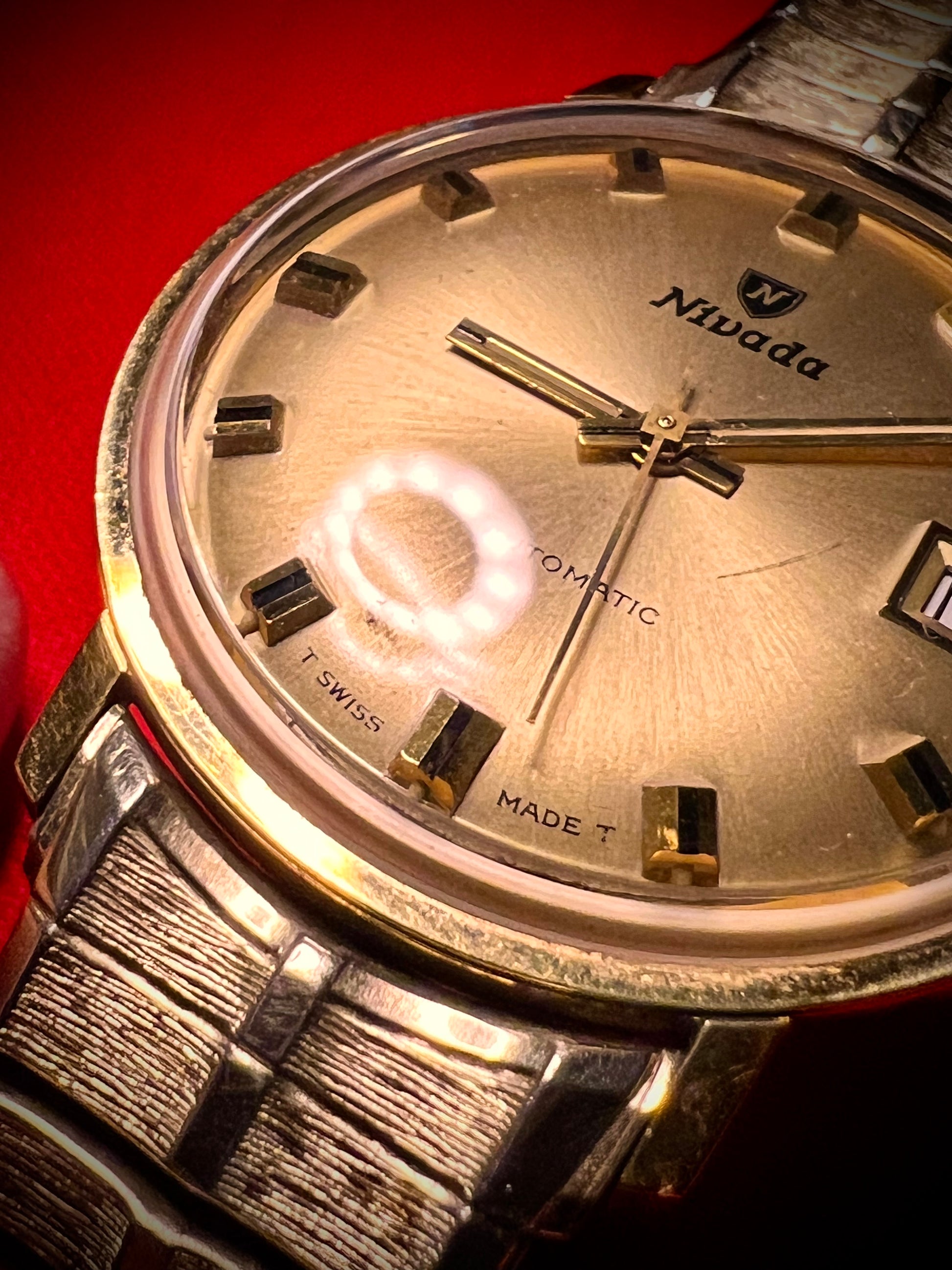 #1351 Nivada Date Automatic Gold color with Gold dial newish beautiful S.S back Spidiel USA gold filled caps all original watch great opportunity for Collectors rate watch in excellent running and beautiful condition. Power 266 beat error 0.1 ms