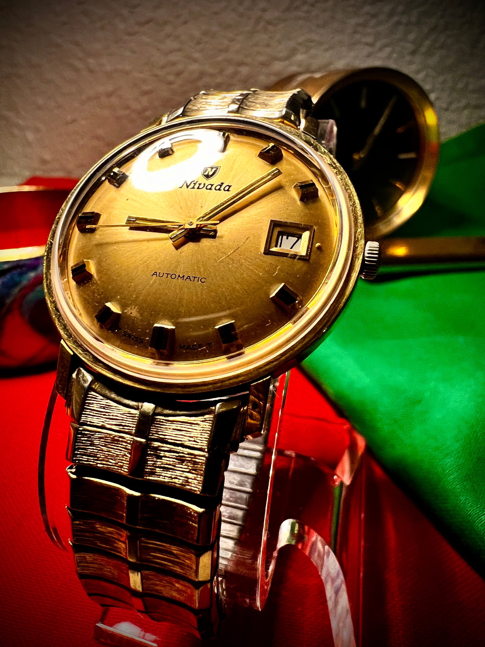 #1351 Nivada Date Automatic Gold color with Gold dial newish beautiful S.S back Spidiel USA gold filled caps all original watch great opportunity for Collectors rate watch in excellent running and beautiful condition. Power 266 beat error 0.1 ms