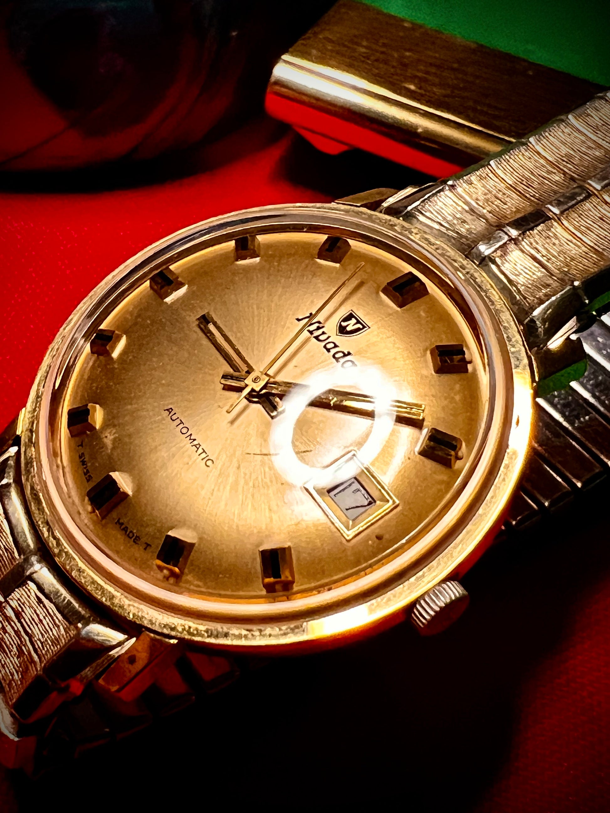 #1351 Nivada Date Automatic Gold color with Gold dial newish beautiful S.S back Spidiel USA gold filled caps all original watch great opportunity for Collectors rate watch in excellent running and beautiful condition. Power 266 beat error 0.1 ms